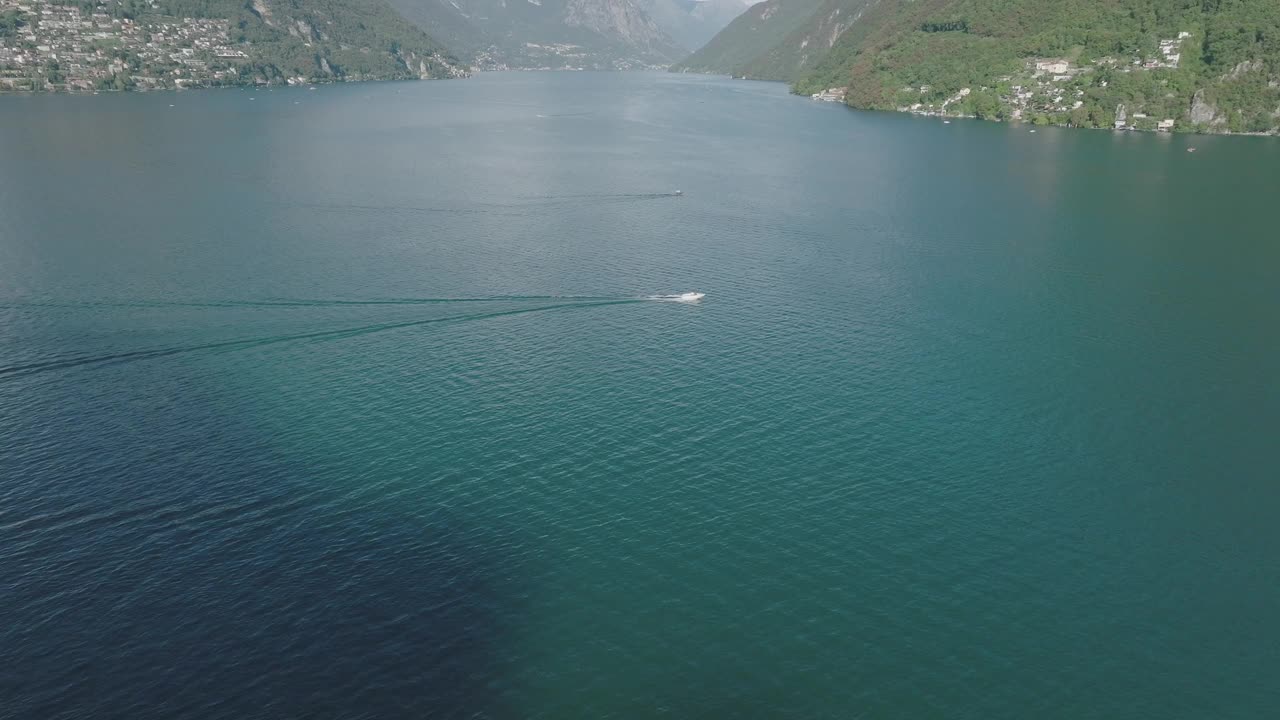 夏日晴空万里，飞越群山环绕的湖泊，远处是卢加诺市视频素材