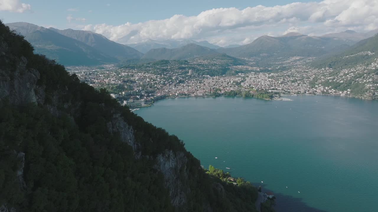 夏日晴空万里，飞越群山环绕的湖泊，远处是卢加诺市视频素材