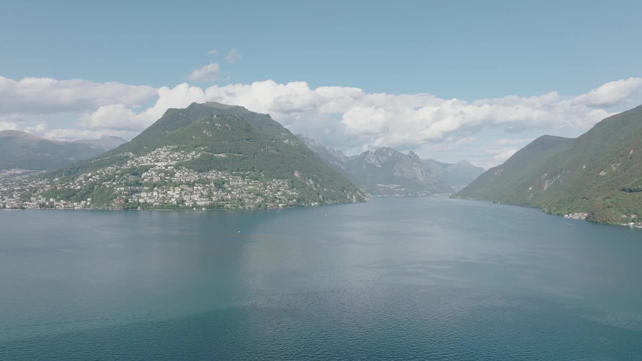 在一个晴朗的夏日，飞越群山环绕的高山湖泊视频素材