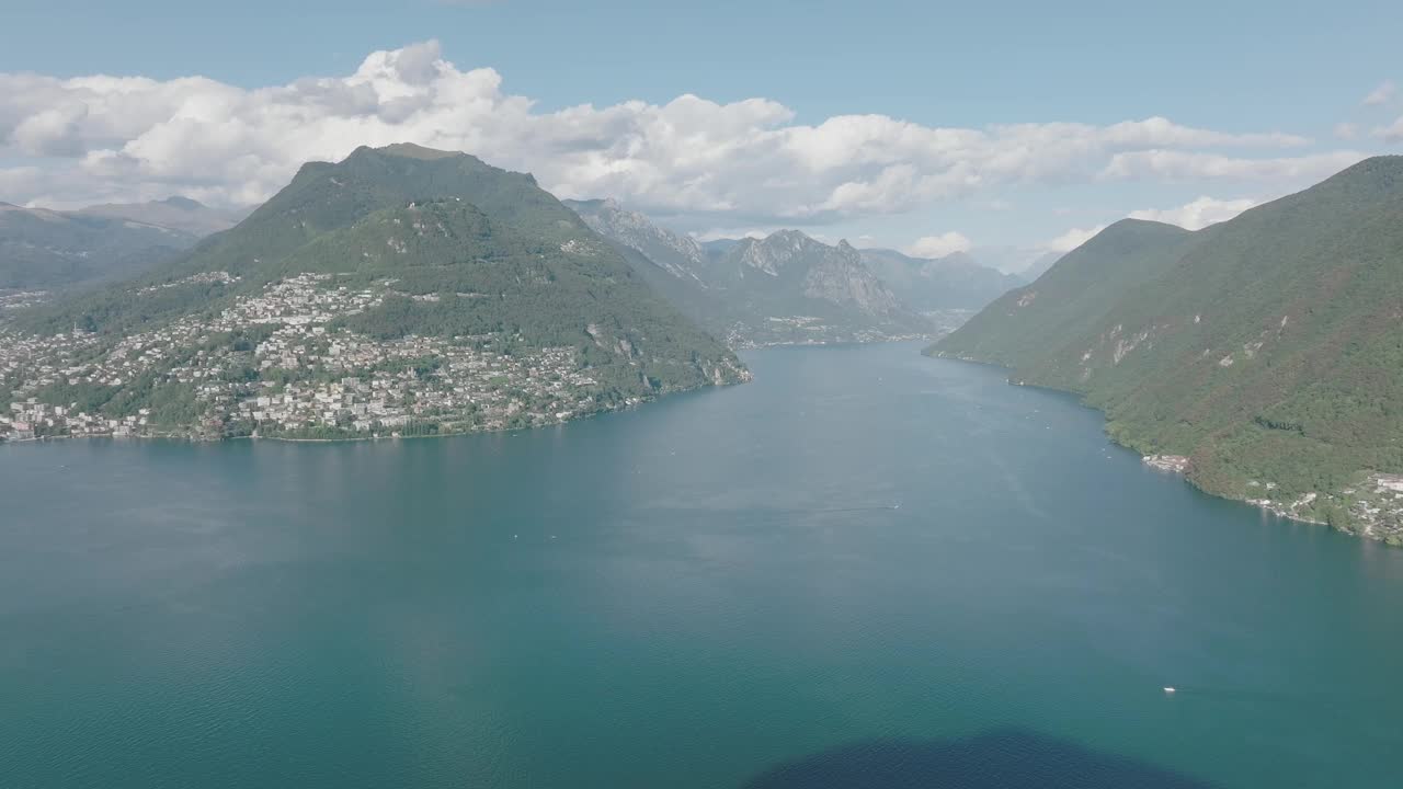 夏日晴空万里，飞越群山环绕的湖泊，远处是卢加诺市视频素材