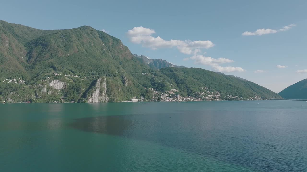 在一个晴朗的夏日，飞越群山环绕的高山湖泊视频素材