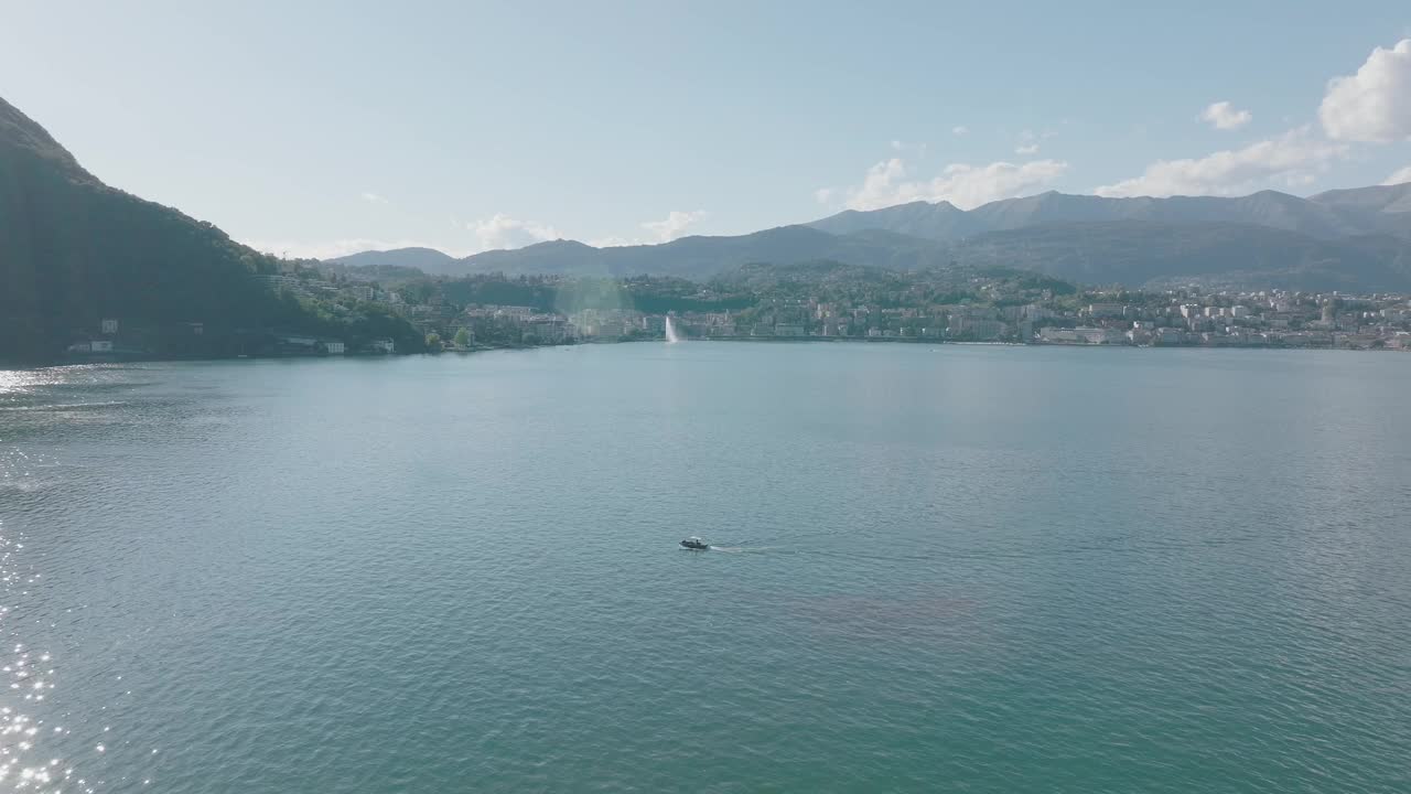 在一个晴朗的夏日，飞越群山环绕的高山湖泊视频素材