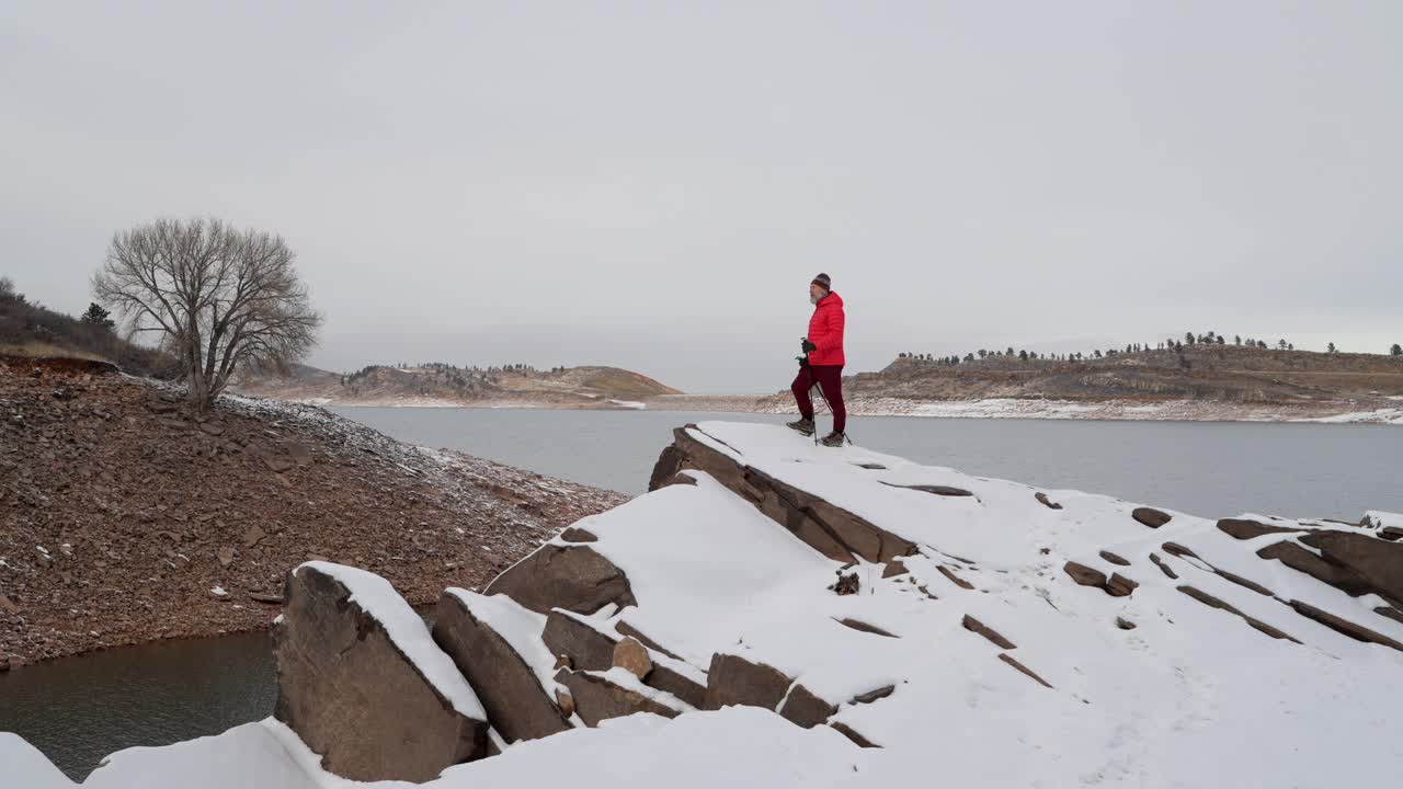 快乐的高级，男性徒步旅行者在山麓湖的岩石岸边徒步视频素材