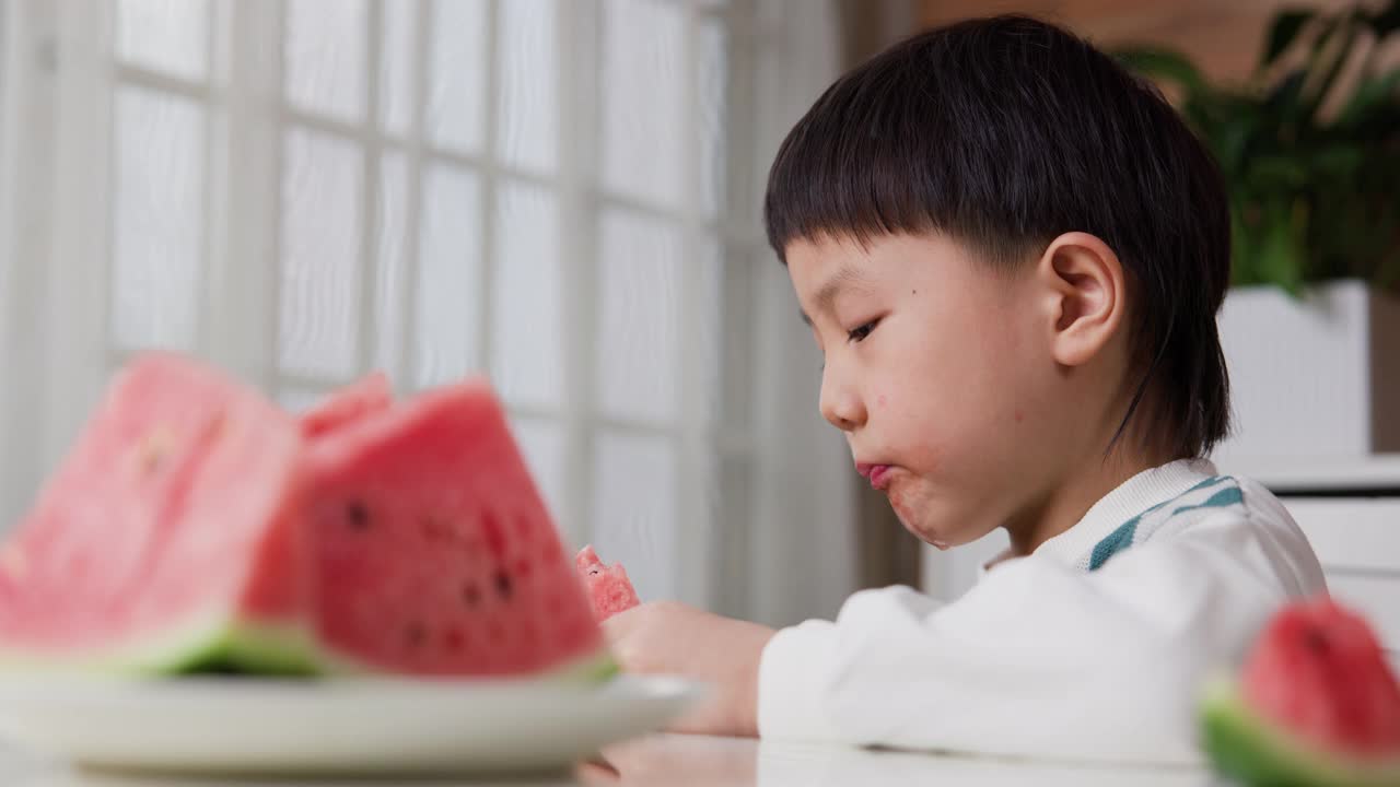 小男孩在阳台上吃西瓜视频素材