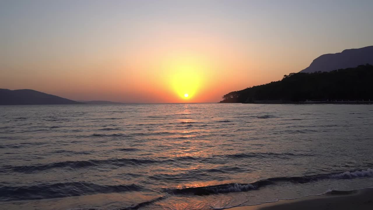 海水背景。在日落和冲浪时，天然的海水表面有波浪。海岸和海滩视频素材