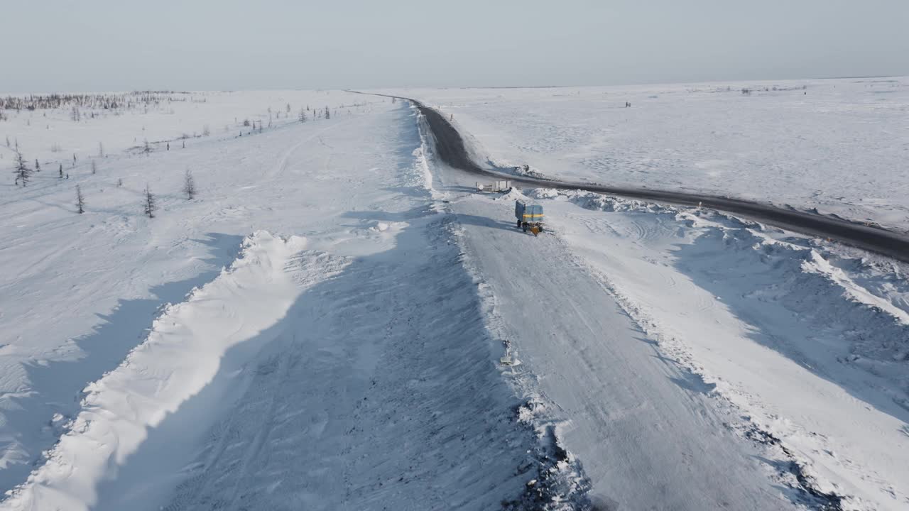 下午，一辆孤零零的Bukhanka汽车行驶在白雪皑皑、空旷的西伯利亚公路上。4 k视频素材