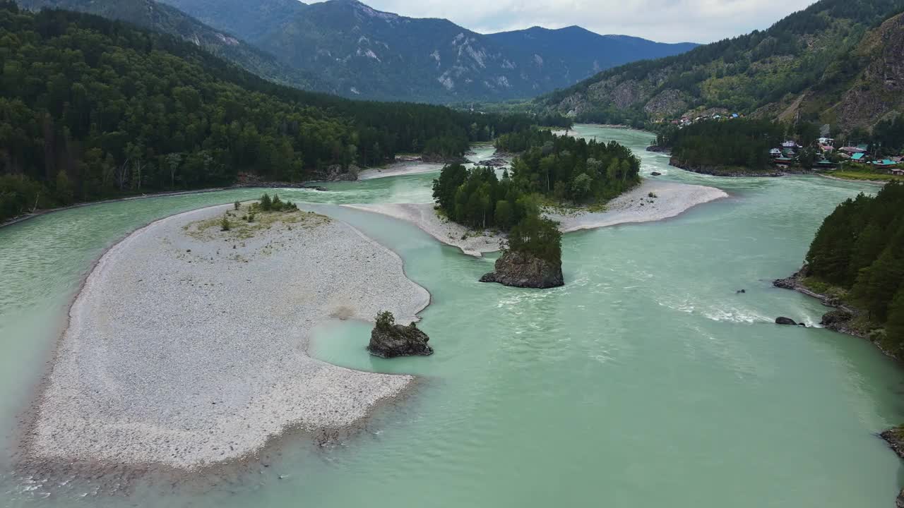 鸟瞰绿松石色的河流在森林覆盖的山谷中流淌视频素材