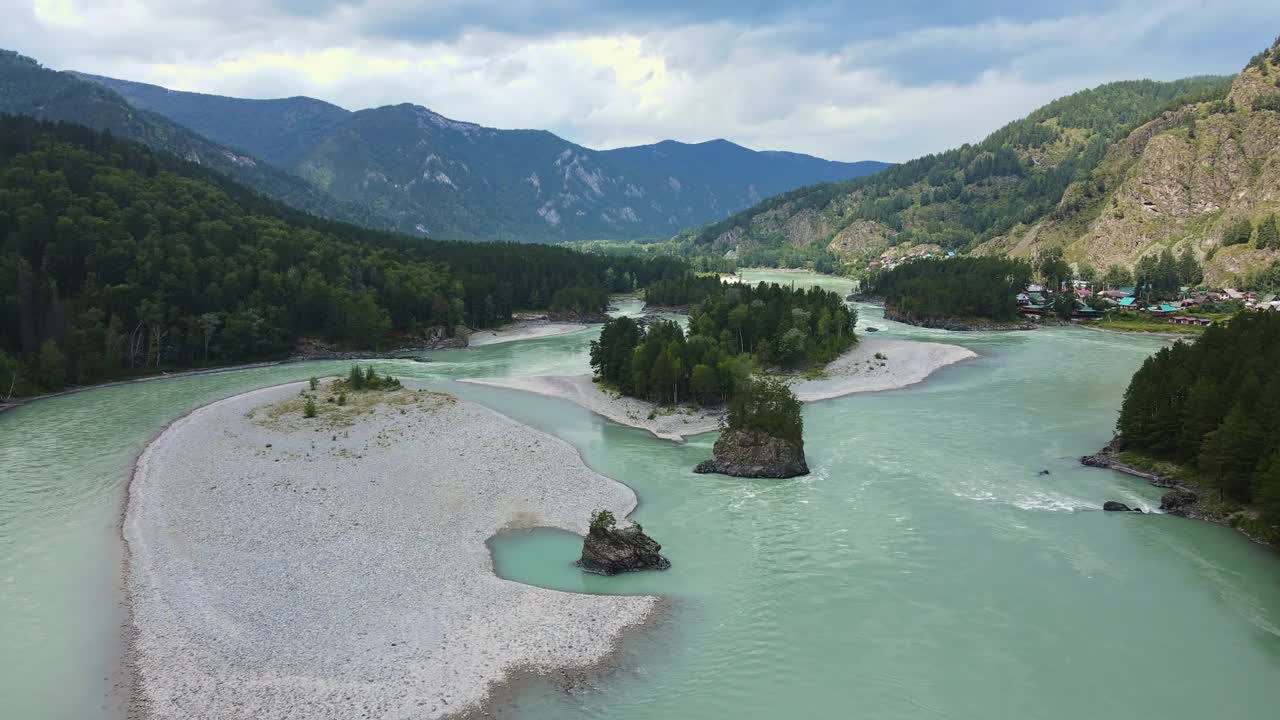 鸟瞰绿松石色的河流在森林覆盖的山谷中流淌视频素材