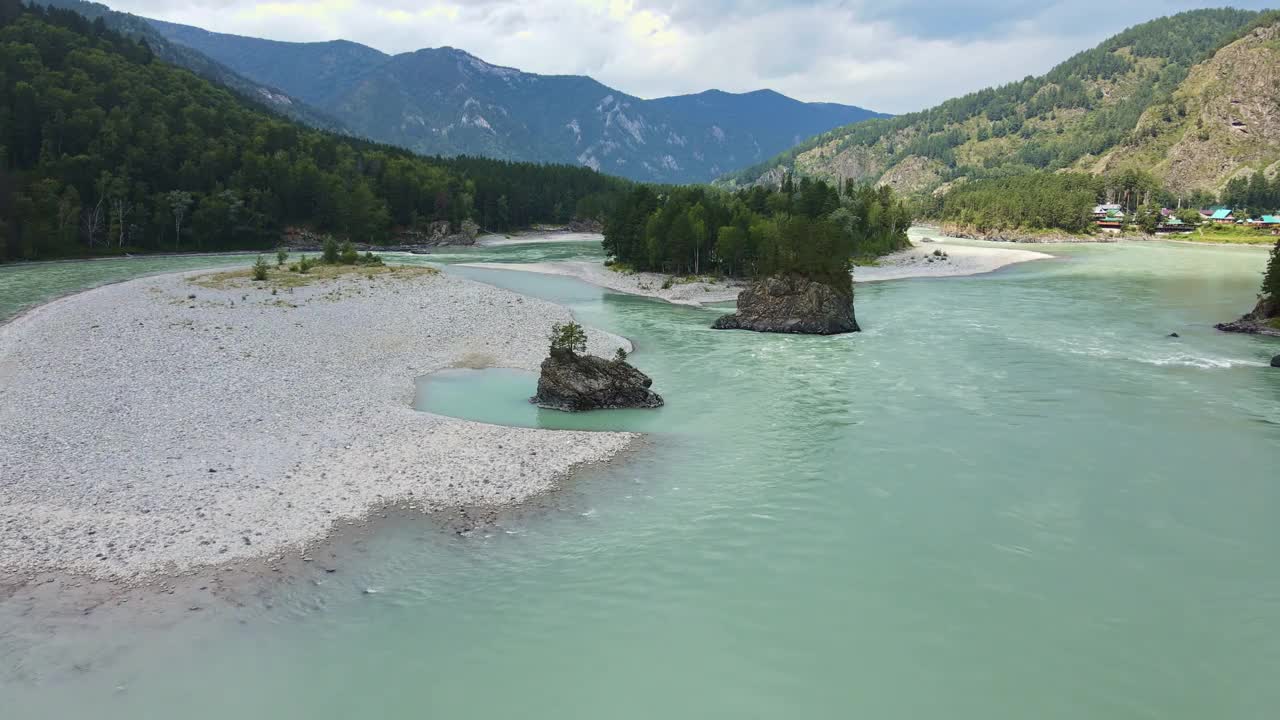 鸟瞰绿松石色的河流在森林覆盖的山谷中流淌视频素材