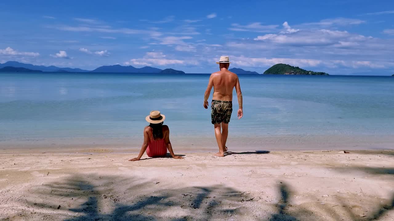 穿着泳装的男人和穿着紧身衣的女人在泰国麦岛的热带海滩上放松视频素材