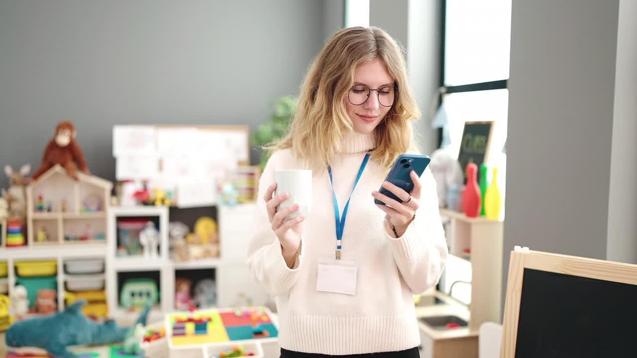 年轻的金发女幼儿园老师用智能手机在幼儿园喝咖啡视频素材