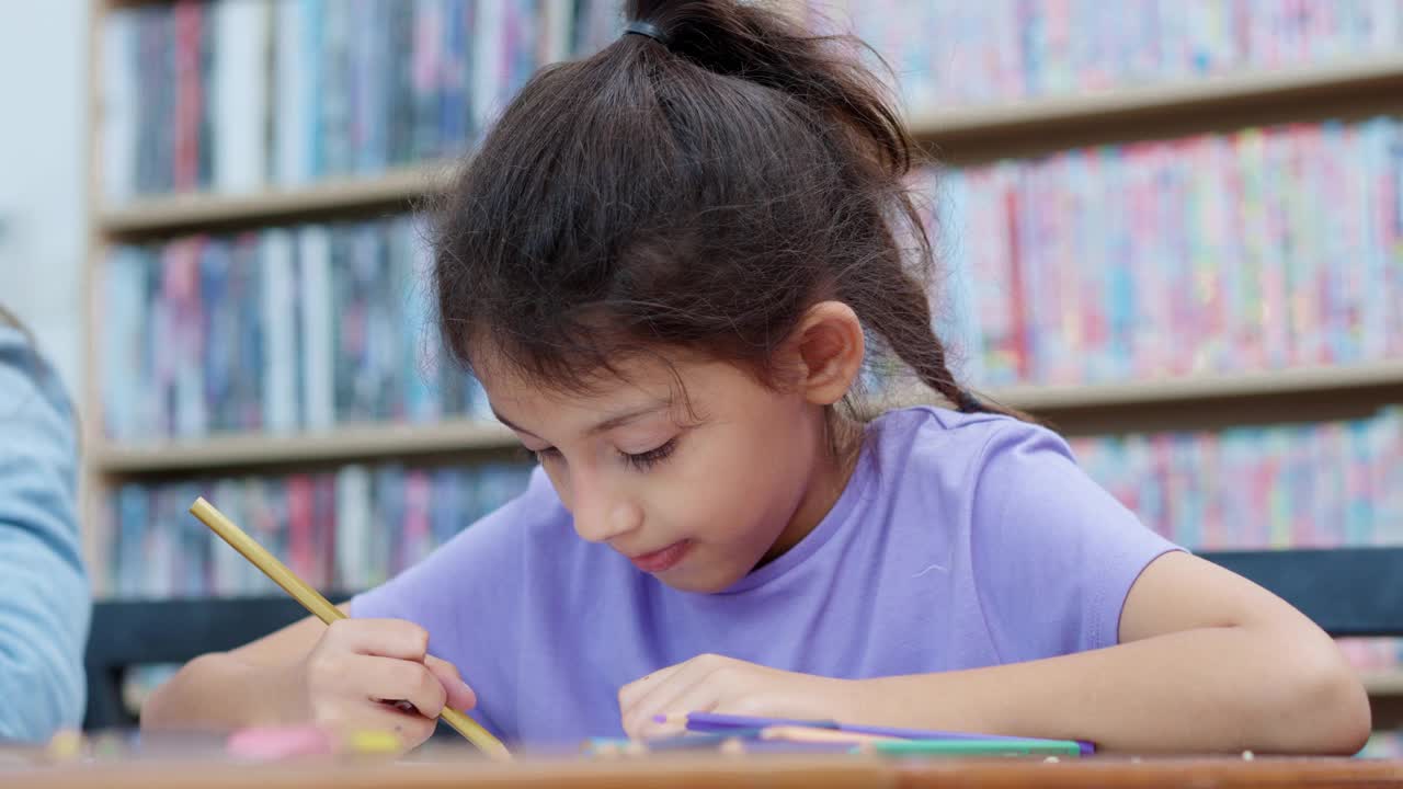 2名白人小学女生正在美术课上学习，正在纸上画画。视频素材