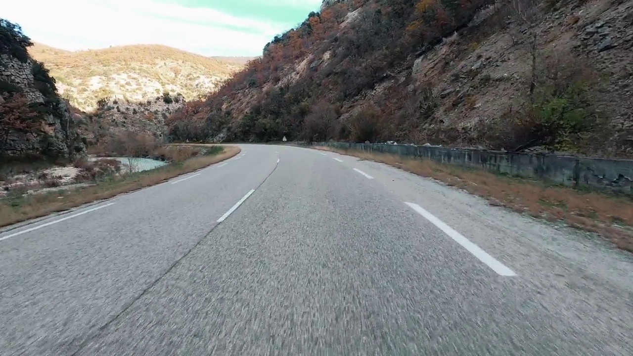 在风景优美的山区，在空旷的道路上自驾旅行。驱动力和目标的概念。风景优美的山谷。假期旅行。地面车视角。速度和移动的车辆。漫漫长路视频素材