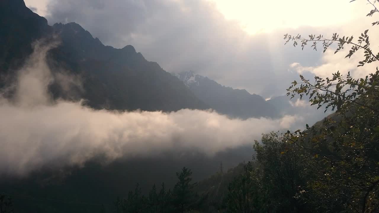 雨后，在阳光的照耀下，厚厚的云层漂浮在山上。视频素材