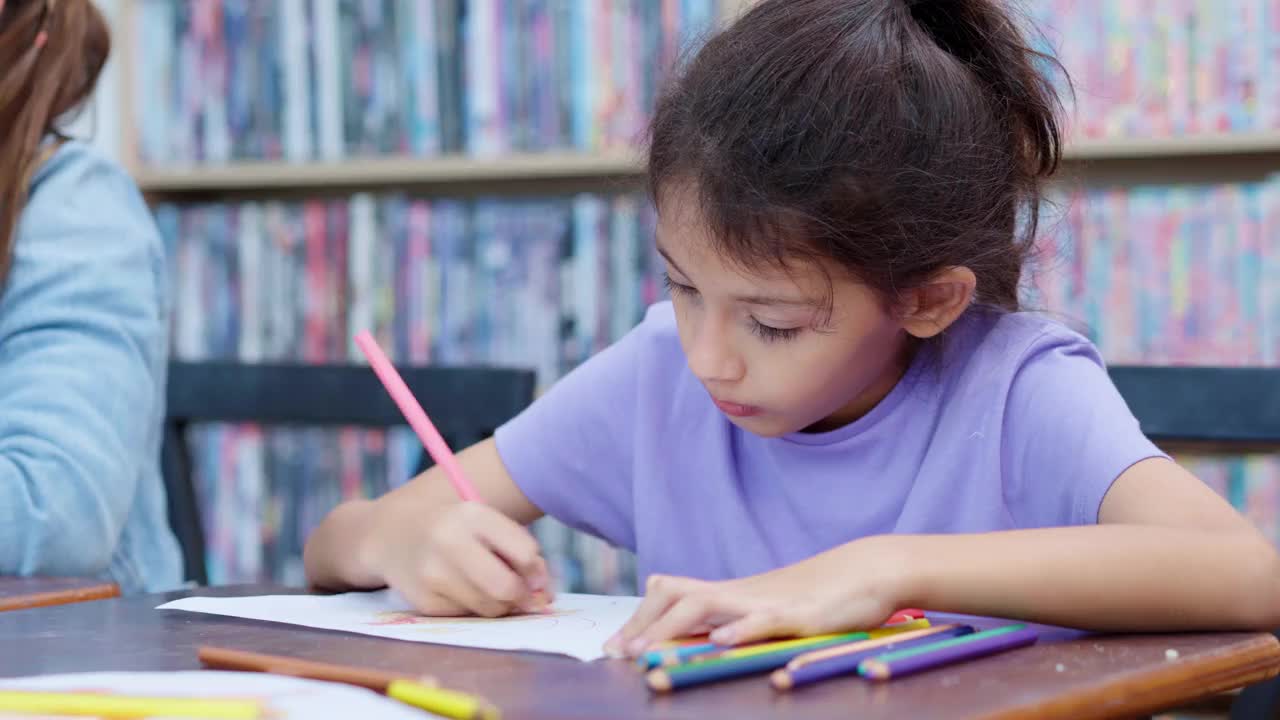 一个白人小学女生在美术课上画画的特写。视频素材