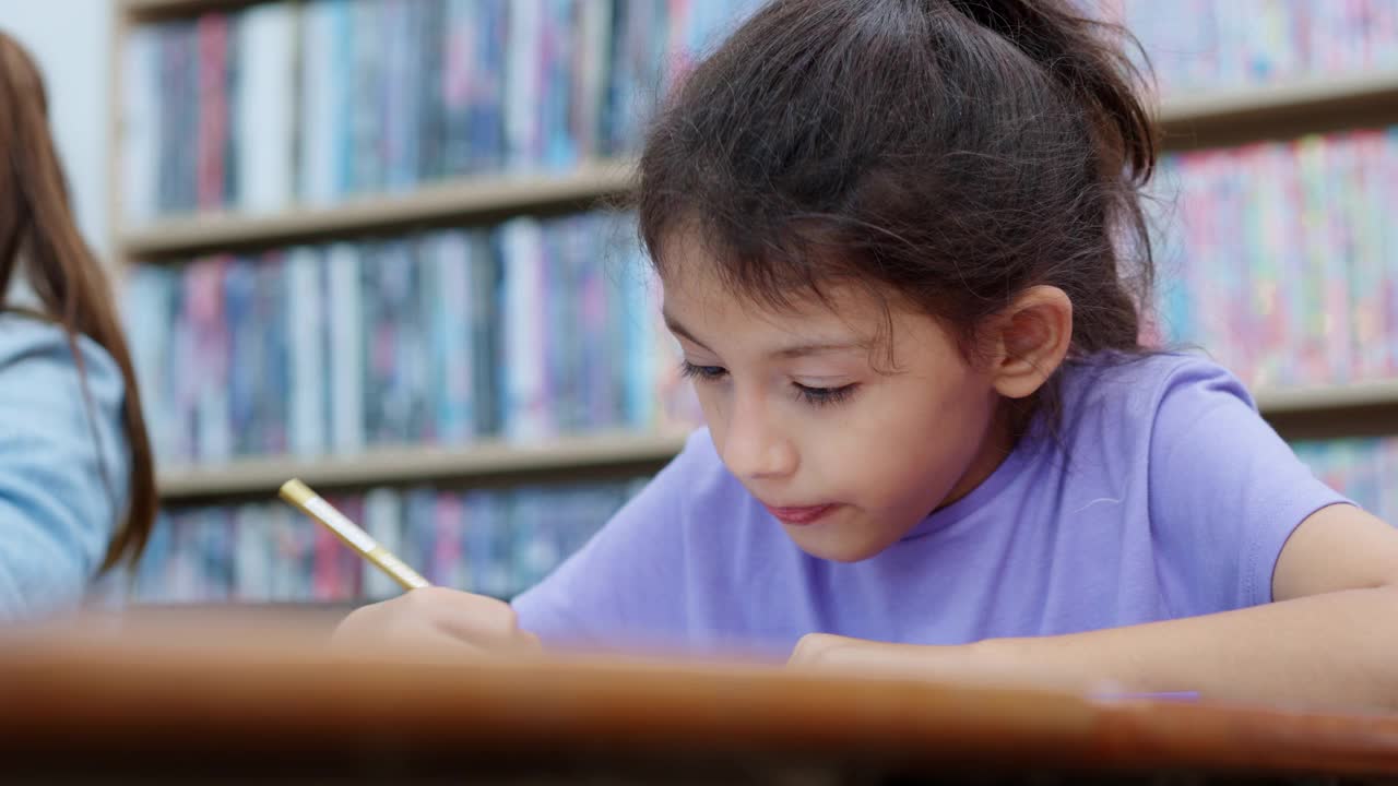 一个白人小学女生在美术课上画画的特写。视频素材