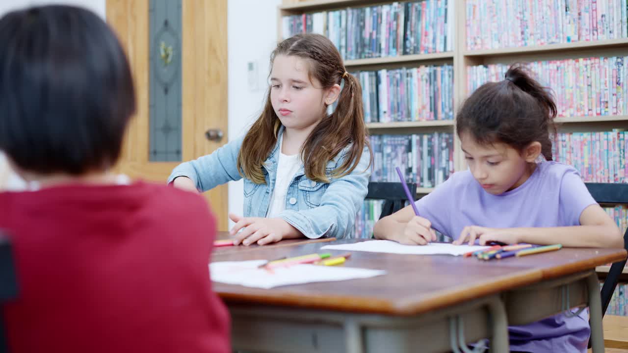 图为，多民族小学的孩子们正在美术课上学习，正在纸上画画。视频素材