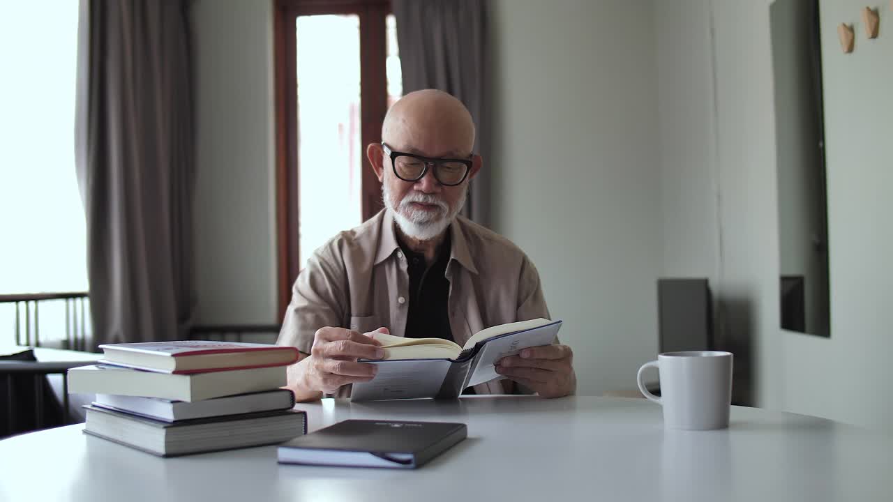 老人在家读书退休，退休生活。年长的男性阅读，放松和坐在沙发上，退休老人和眼镜的视力视频素材