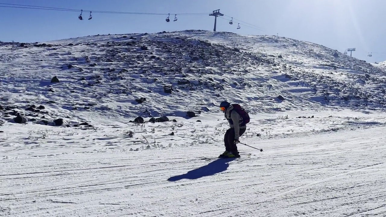 年轻的成年男子在滑雪场的山上滑雪视频素材