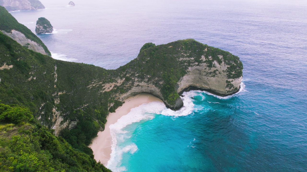 克林京海滩努沙佩尼达是印尼必去的旅游景点。蓝绿色的海洋景观，白色的沙滩。热带性质。空中无人机飞行。视频素材