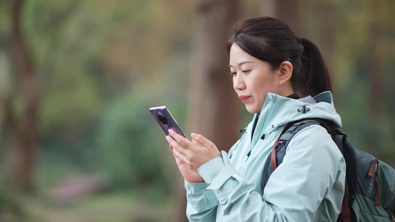 亚洲女性在户外使用智能手机视频素材