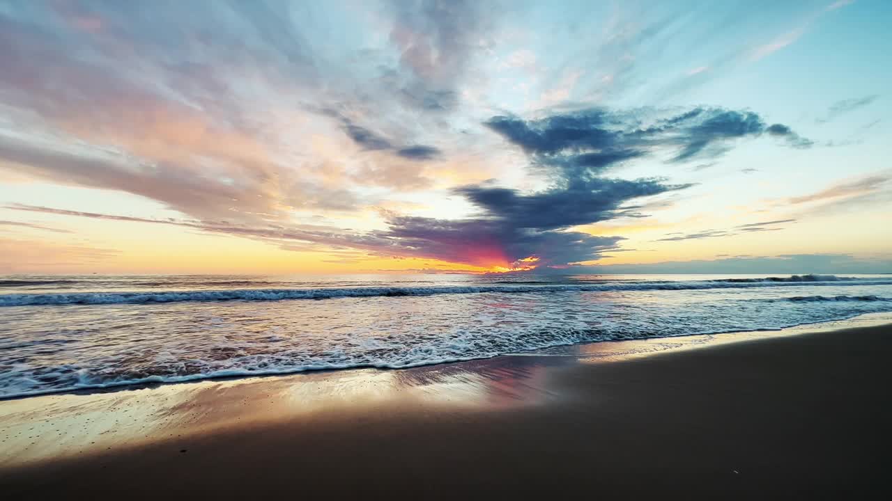 Majestic sunset at sea and dramatic clouds reflecting on sanв视频素材