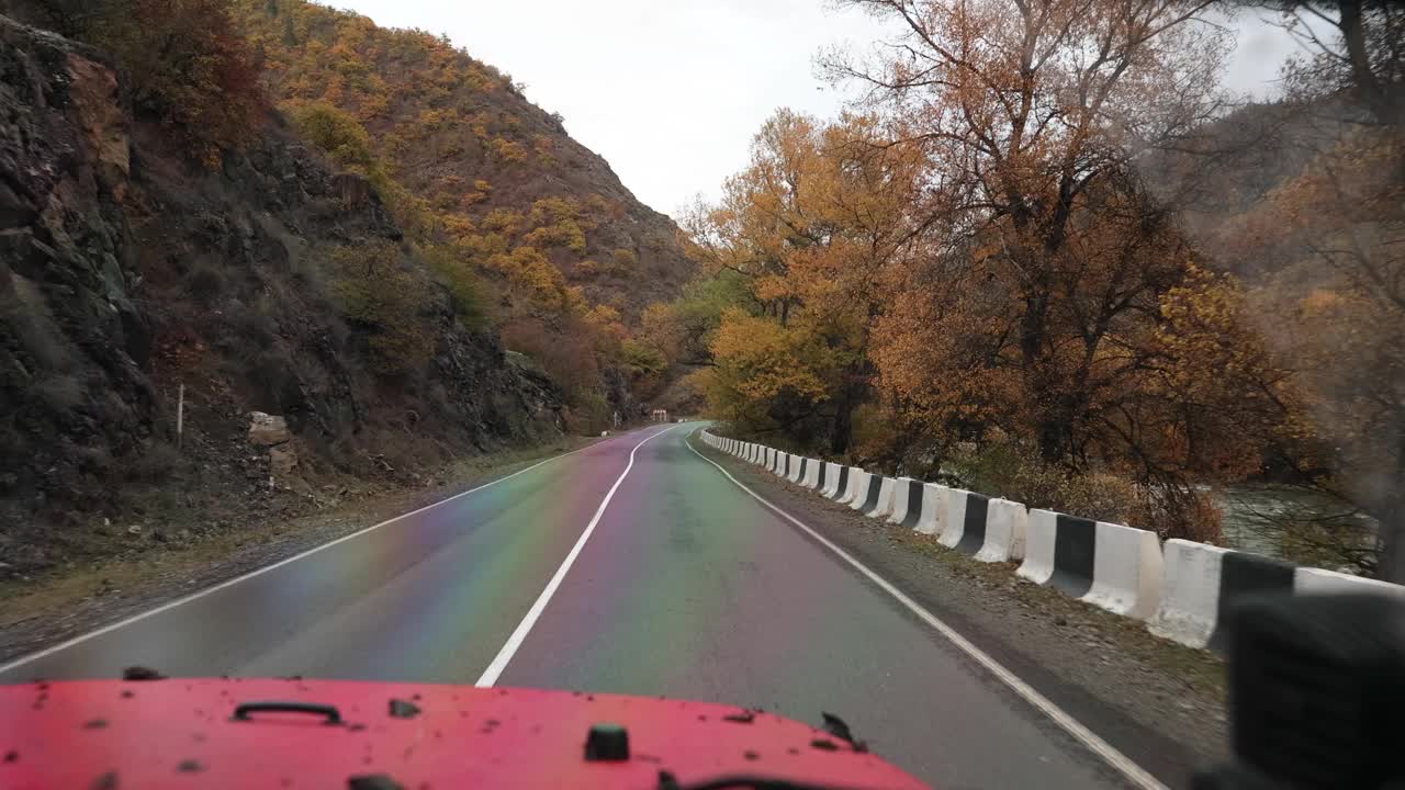 旅行者驾驶红色汽车在山路上雨4k电影慢动作视频素材