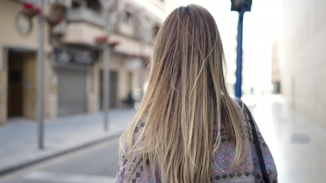 年轻的金发女子站在手臂交叉的姿态在街上视频素材