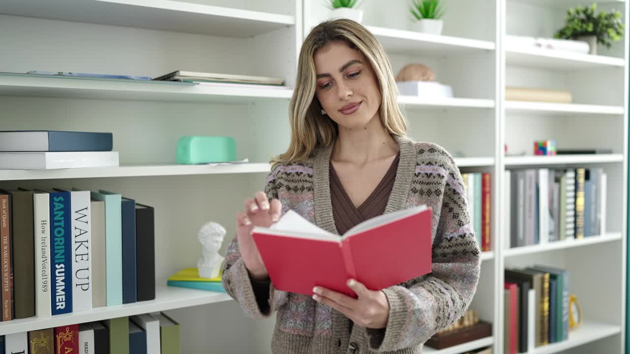 年轻的金发女老师在图书馆大学读书做沉默的手势视频素材