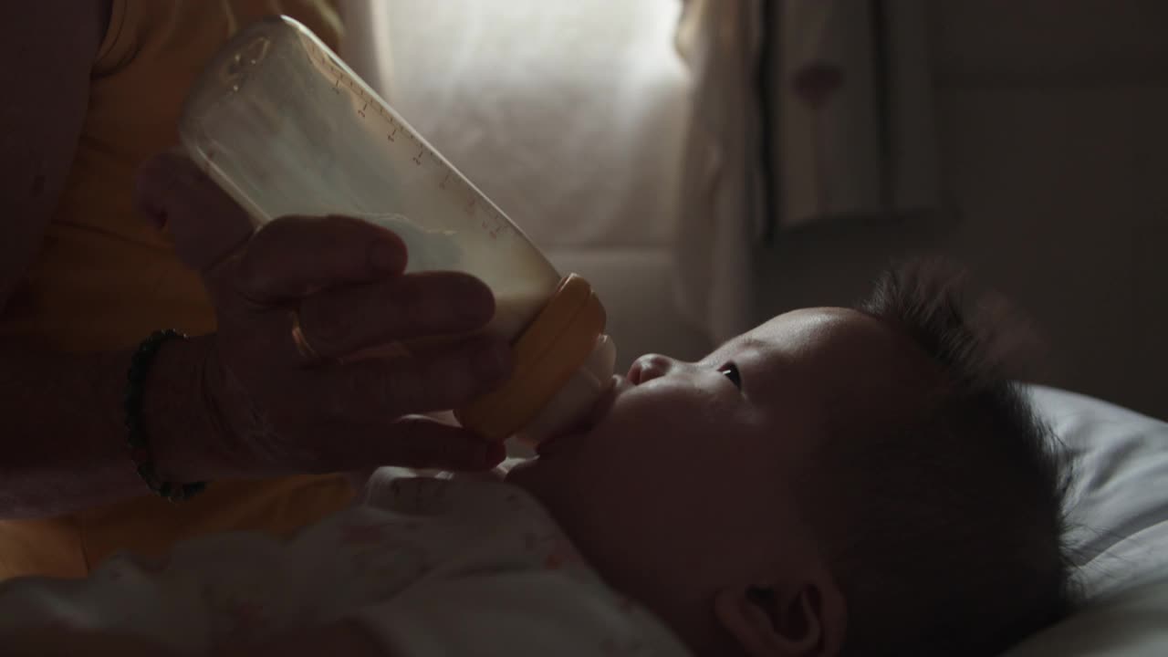 奶奶给婴儿喂配方奶。视频素材