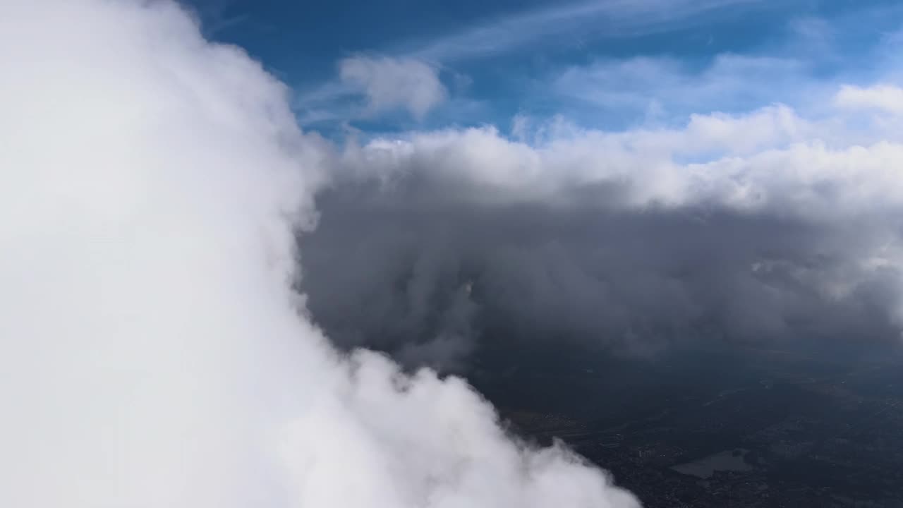 从飞机窗口俯瞰被白色蓬松积云覆盖的高空地面视频素材