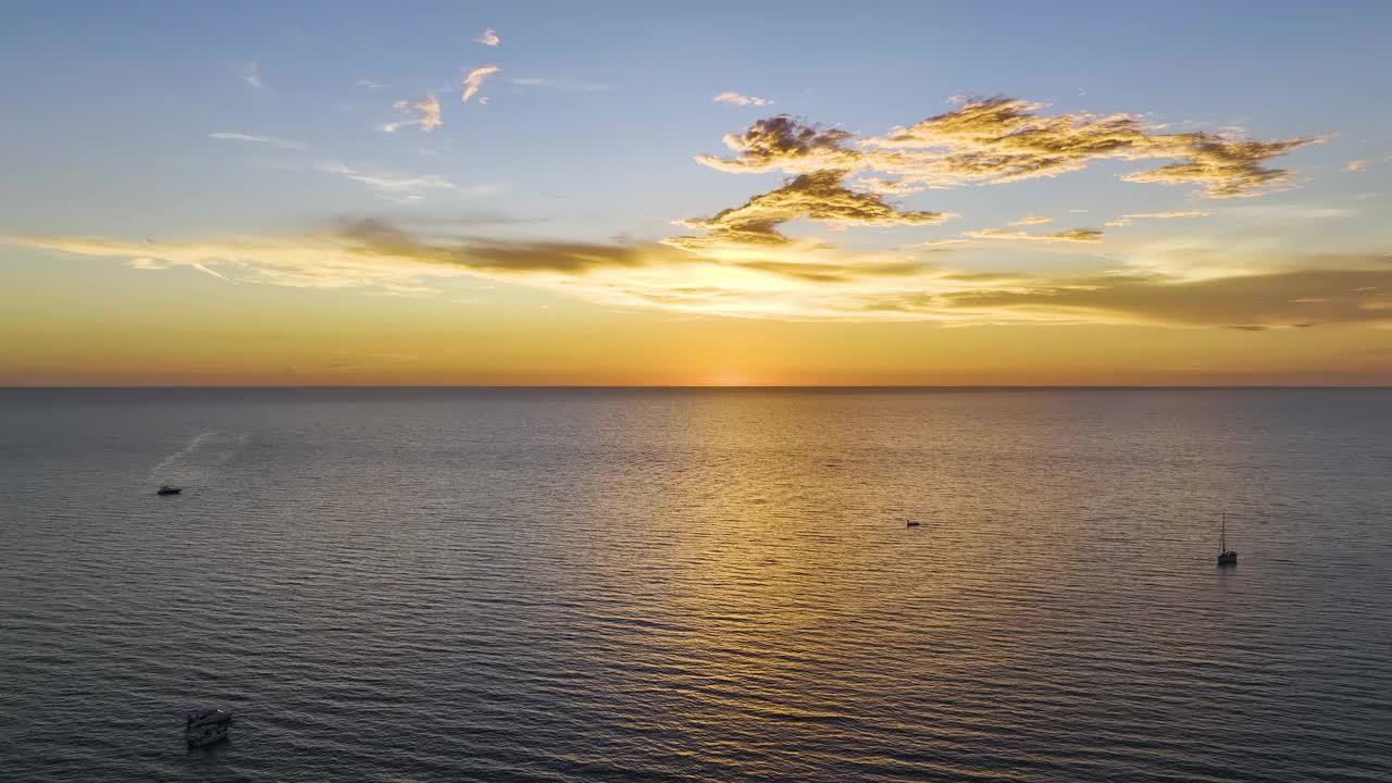 日落时漂浮在海浪上的白色游艇的鸟瞰图。海面摩托艇娱乐视频素材