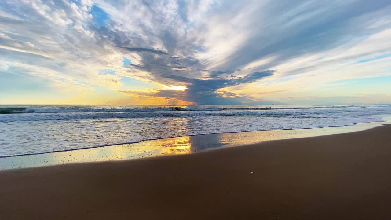 Majestic sunset at sea and dramatic clouds reflecting on sanв视频素材