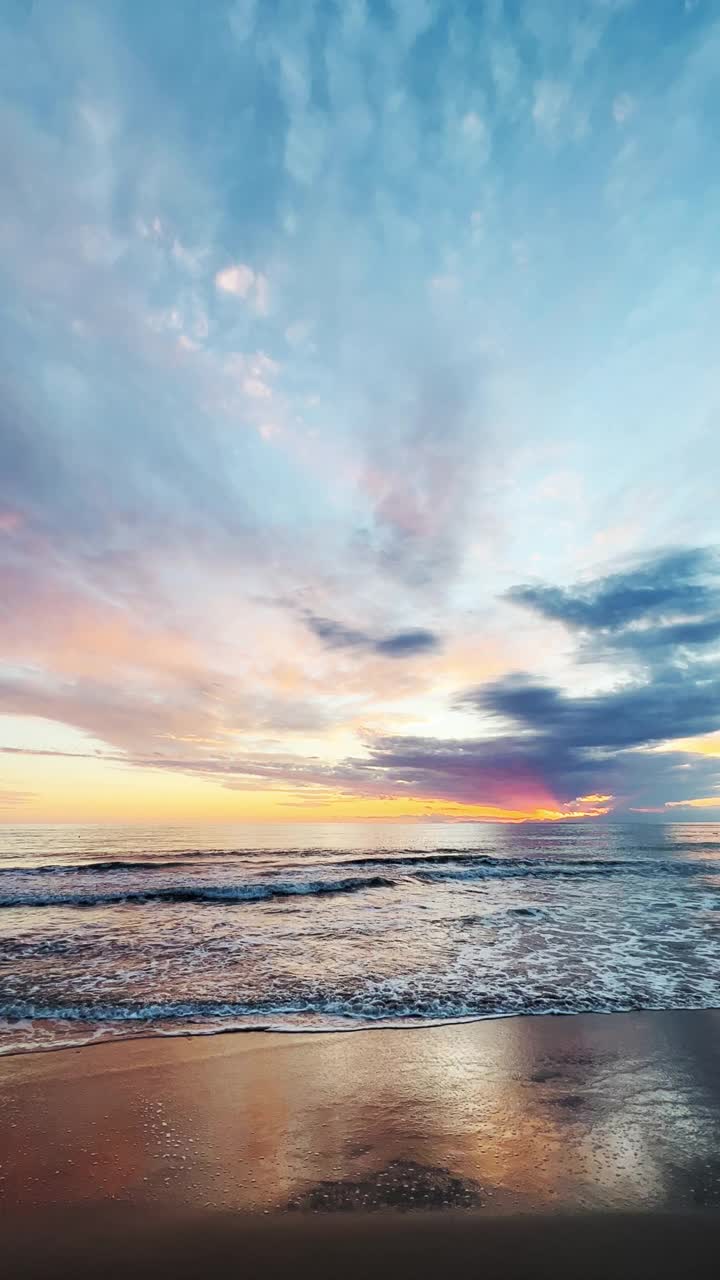 Majestic sunset at sea and dramatic clouds reflecting on sanв视频素材