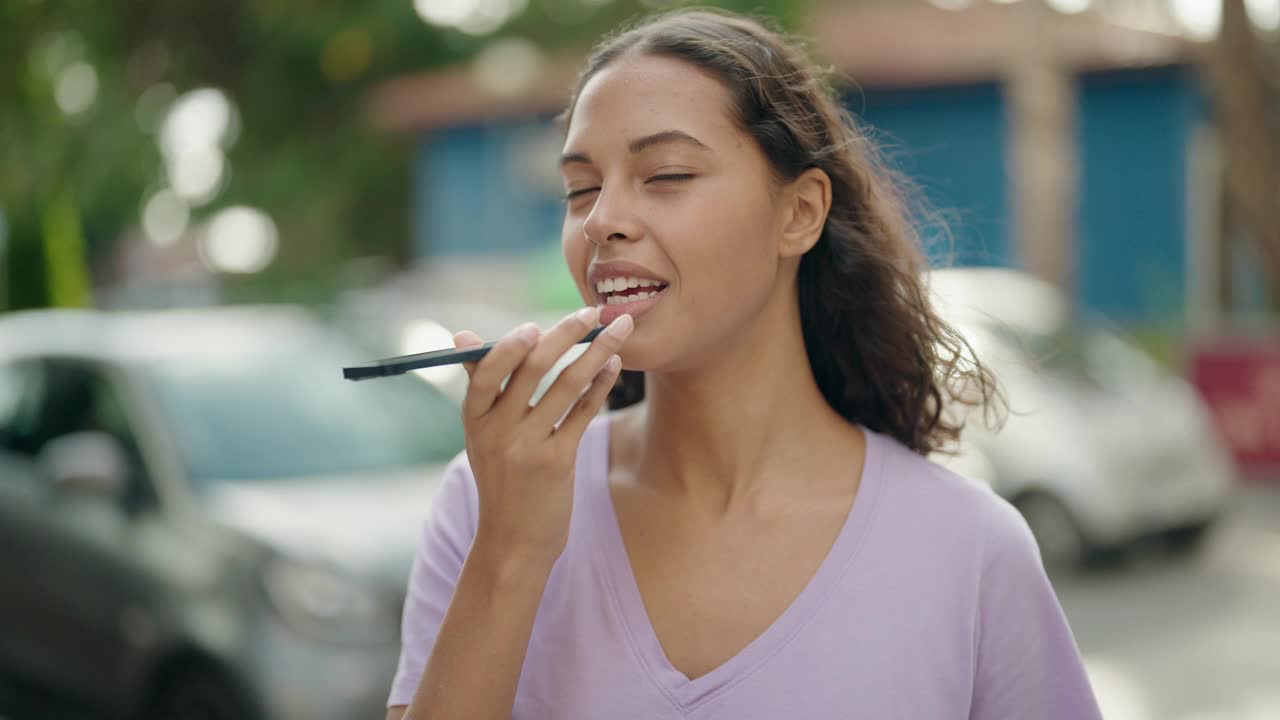 年轻的非裔美国妇女微笑着自信地在街上用智能手机说话视频素材