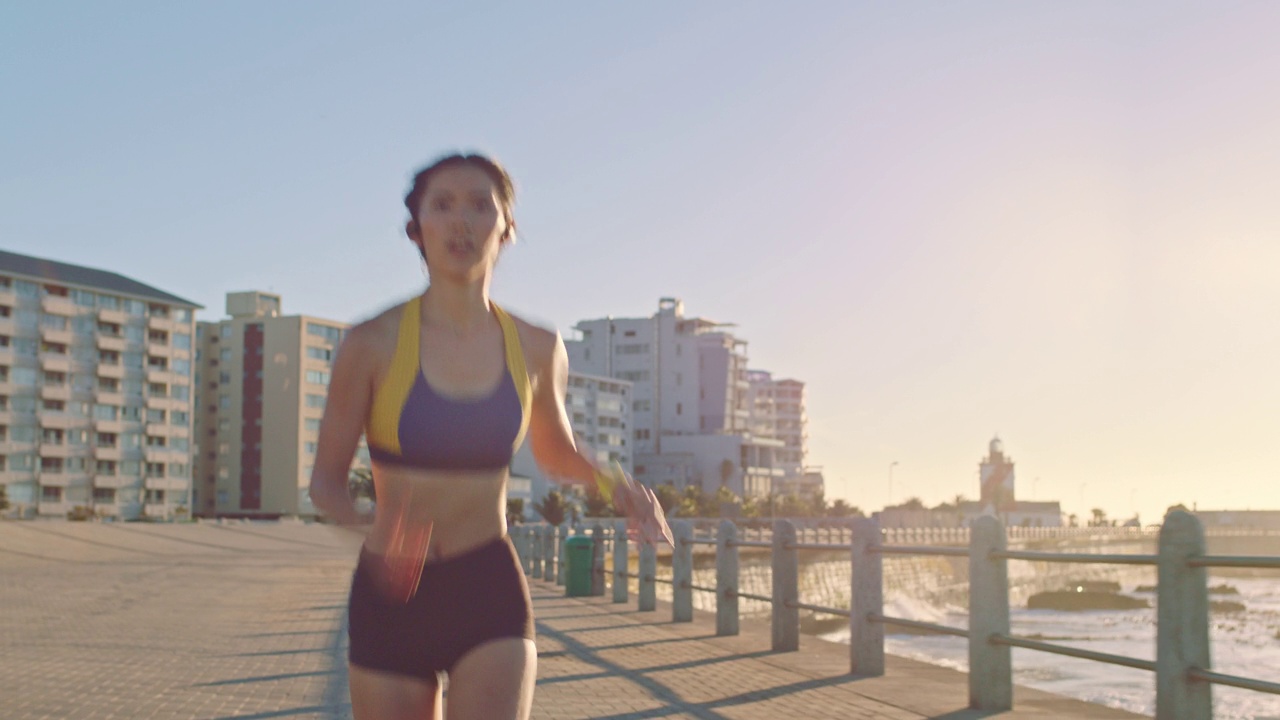 沙滩，跑步和运动健身的女子跑步靠海，海水与速度。一个人在室外水泥地上进行健康锻炼的运动、马拉松训练和运动员跑视频素材