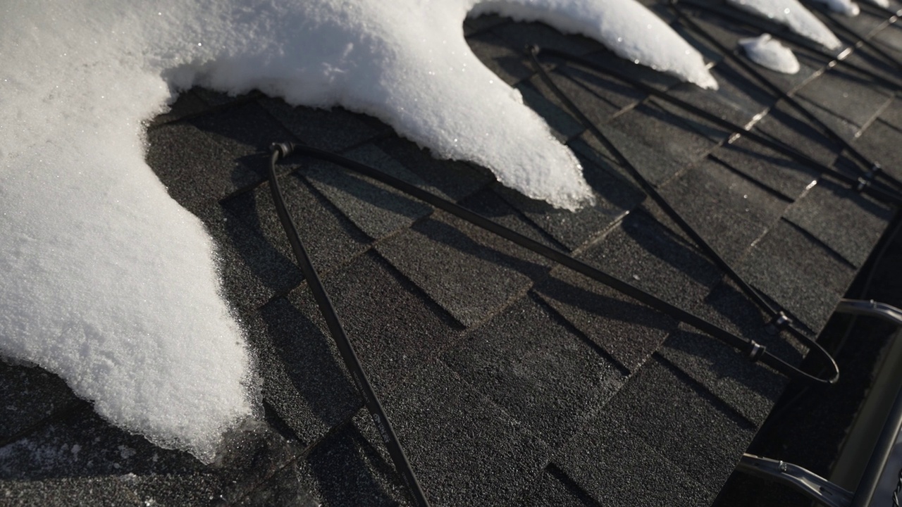 屋顶边缘的冬季热电缆正在融化积雪视频下载