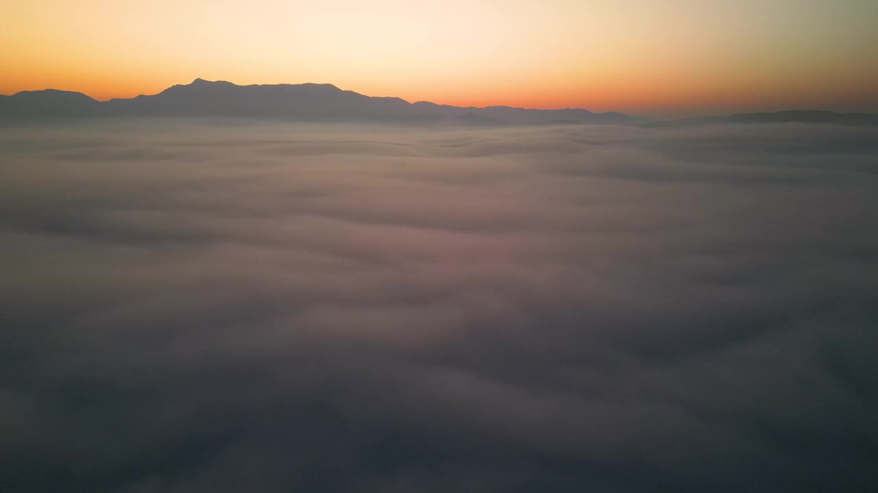 空中拍摄的云和移动的雾在山上与日出视频素材