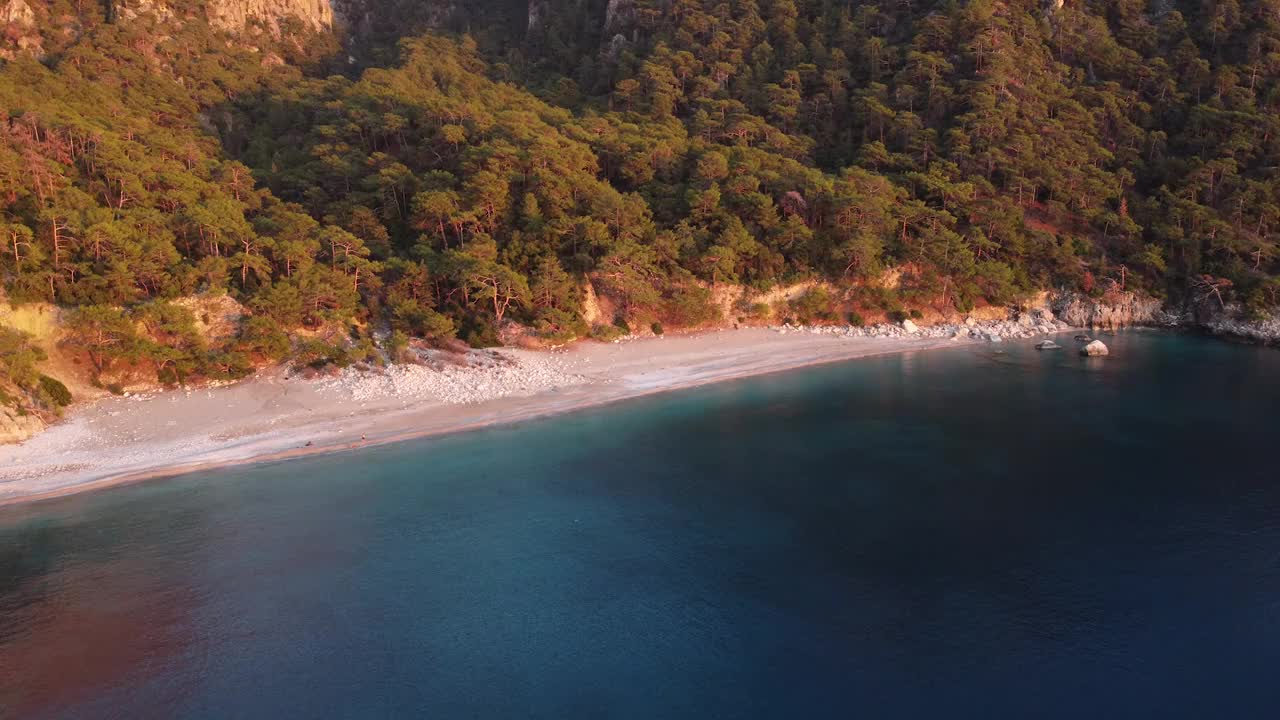 野生海滩在一个美丽的海湾与山脉的背景视频下载