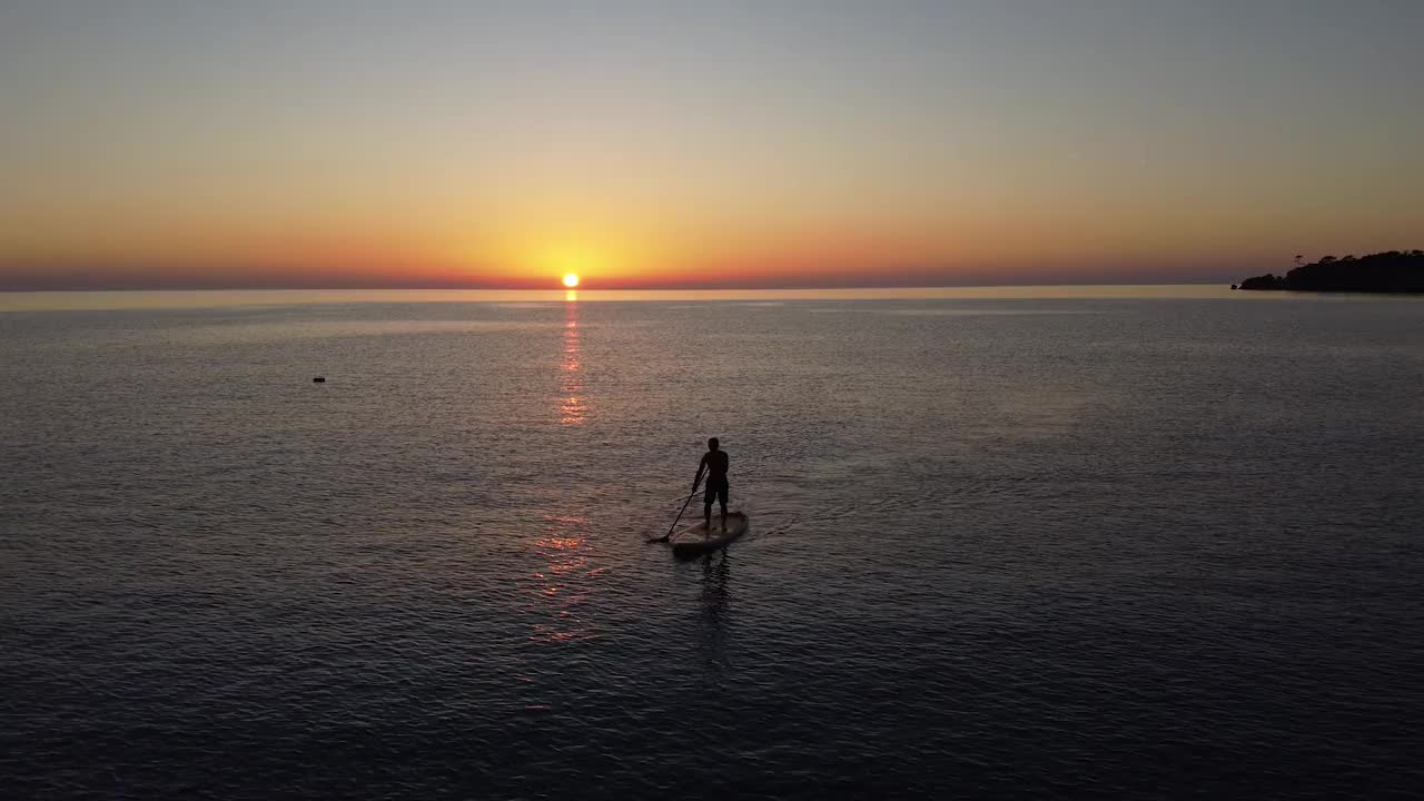 日落时分，一个人在海上的SUP板上视频素材