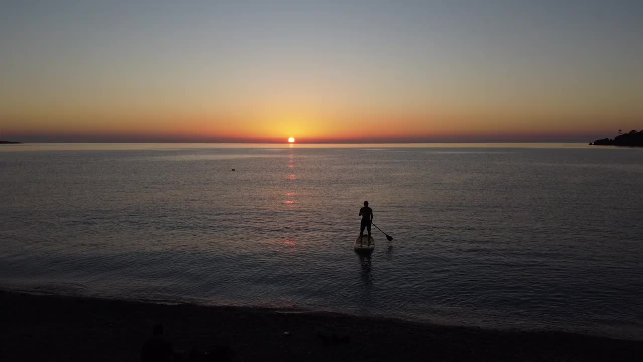 日落时分，一个人在海上的SUP板上视频素材