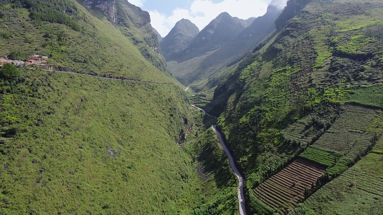 鸟瞰美丽的公路之间的高山，周围的绿色森林和水稻种植园视频素材