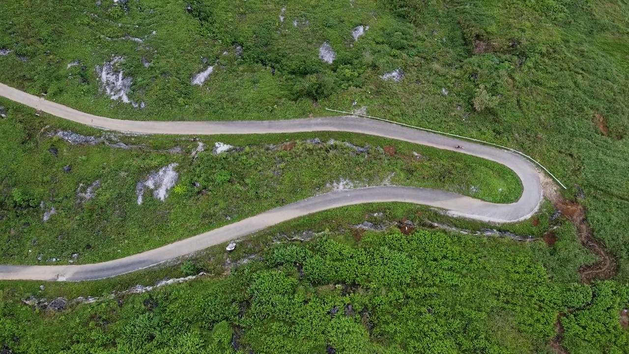 山间公路鸟瞰图，穿过森林景观，从高山口蜿蜒的道路。山间弯弯曲曲的小路，无人射击视频素材