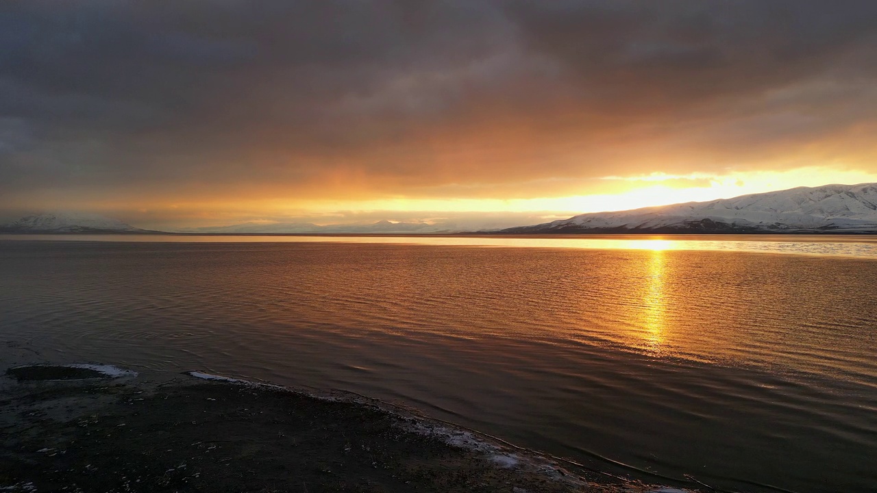 沿着犹他湖的海岸线飞行，反射出夕阳的余晖视频素材