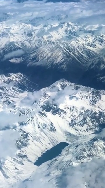 鸟瞰迷人的雪山和蓬松的白云视频素材