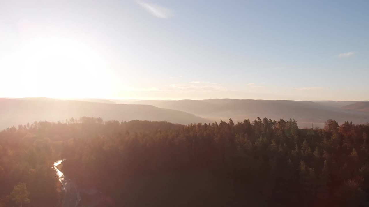 空中拍摄的乡村景观，在阳光明媚的天气里有森林和山丘视频素材