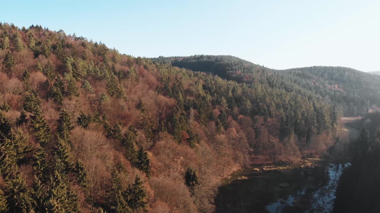 空中拍摄的乡村景观，巨大的山丘覆盖在郁郁葱葱的自然和阳光下的树木视频素材