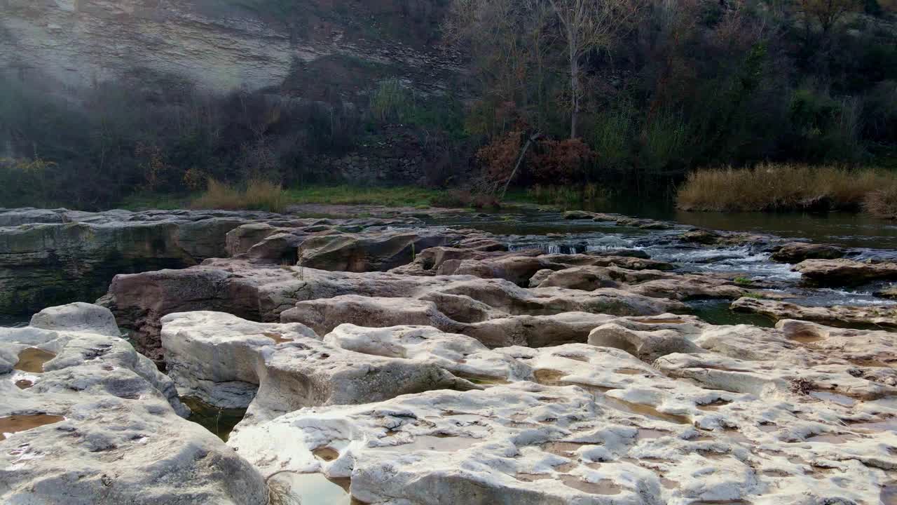 河流附近的岩石地面，背景是秋天的树木视频素材