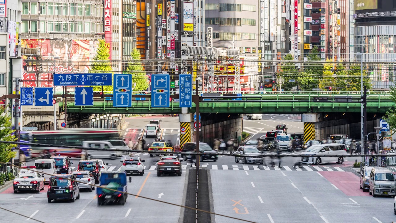 时间流逝的汽车，公共汽车交通运输在道路上，地铁列车在高架铁路轨道上，日本人走过交叉路口在新宿区，日本东京。亚洲交通，亚洲城市生活。视频素材