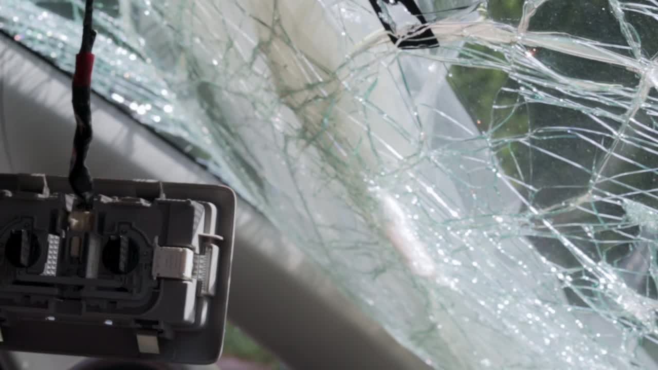 严重车祸造成的汽车挡风玻璃上的洞。汽车保险。前挡风玻璃破碎的车辆。道路安全与保险的概念。车祸后的破车。视频下载